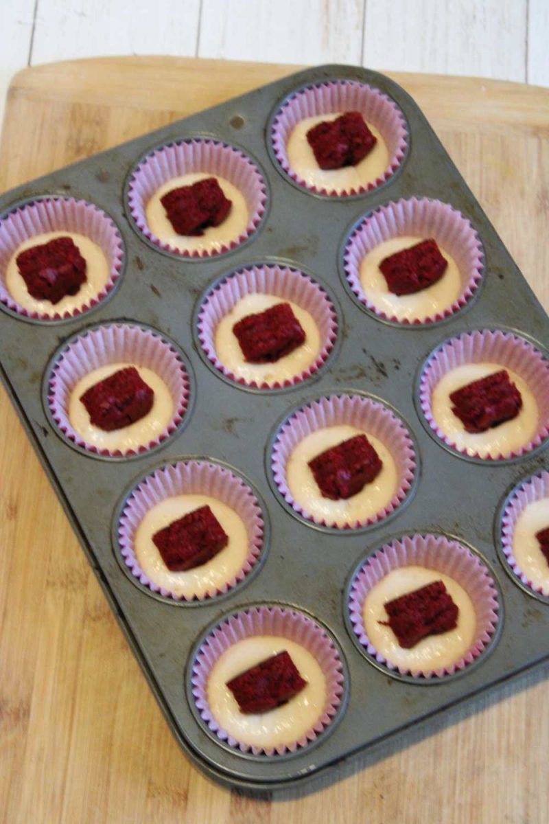 Inserting red cake hearts into cupcakes